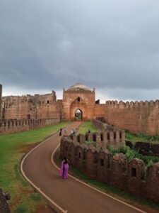 A scenic view of a historic fortress and gothic architecture under a cloudy sky, inviting exploration.